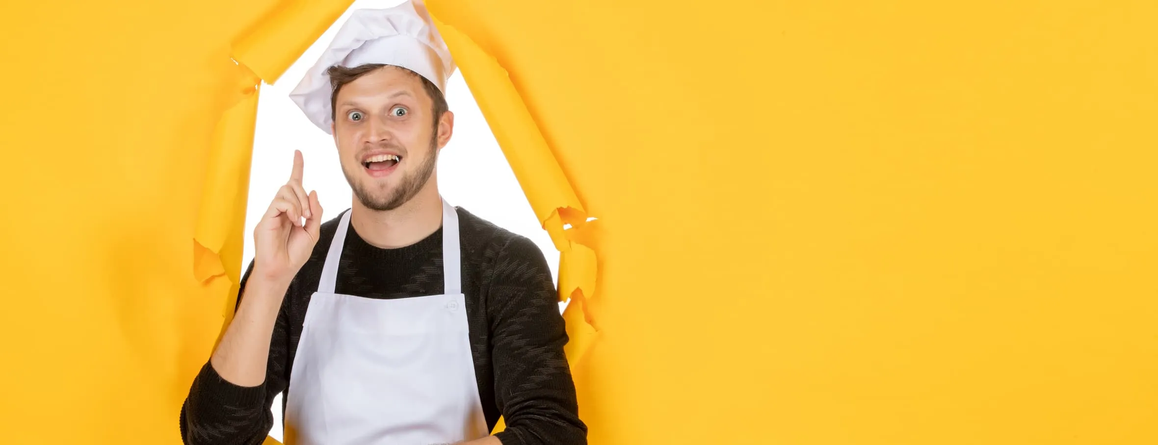 A chef stepping through a wall of yellow paper